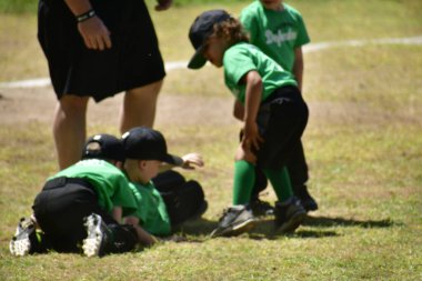 Baharda beyzbol oynayan üç çocuk.