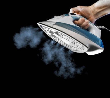Iron with steam in hand, isolated on black background clipart