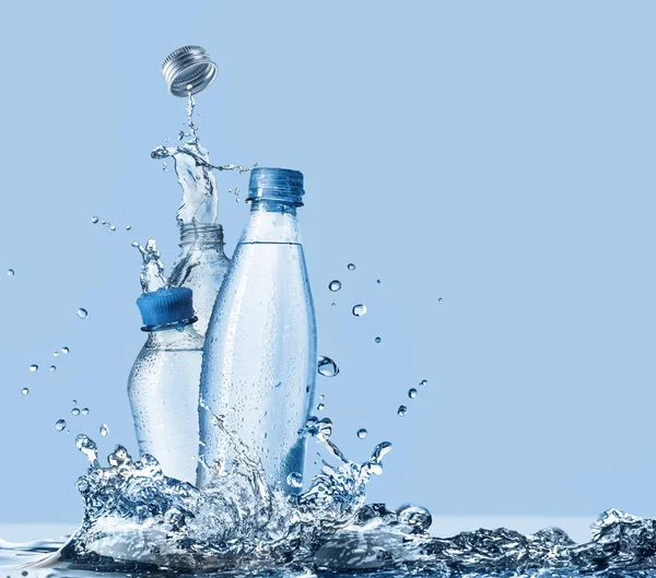 Ivóvíz Ásványvíz Műanyag Palackokban Fröccsenő Körül Kék Alapon — Stock Fotó
