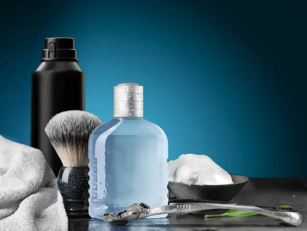 Shaving accessories with razor, shaving foam, shaving brush, lotion spray on blue background