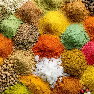 Arka plandaki baharat ve baharatların çeşitliliği. Doğal baharatların doğrudan yukarısında çeşitliliği
