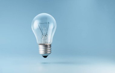 Mavi arkaplan üzerinde yükselen ampul