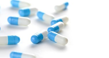 Beyaz arka planda mavi beyaz ilaç kapsülleri. Yakın plan. Antibiyotikler