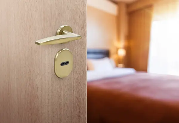 Half opened door of hotel room or apartment doorway with and blur interior background