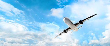 Pofuduk beyaz bulutlarla parlak mavi gökyüzünde süzülen ticari bir jet uçağı seyahati simgeliyor..