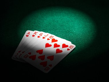 Sahne ışıkları kalplerin kraliyet floşuna, kazanan poker eline kumarhanedeki yeşil keçeli masaya parlıyor.