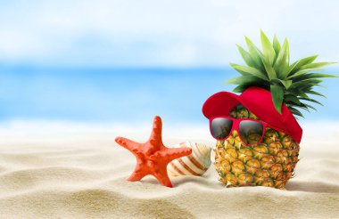 Güneş gözlüğü takan neşeli bir ananas ve manzaralı deniz kenarında şık bir şapka, yaz havası için mükemmel.