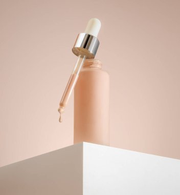 Pembe arka planda bir şişedeki sıvı BB vakfı modern güzelliğin ve son kozmetik eğilimlerin bir örneği.