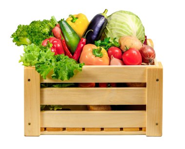 Güzel düzenlenmiş ahşap sandık ağzına kadar çeşitli taze ve canlı sebzelerle dolu beyaz manzaralı.