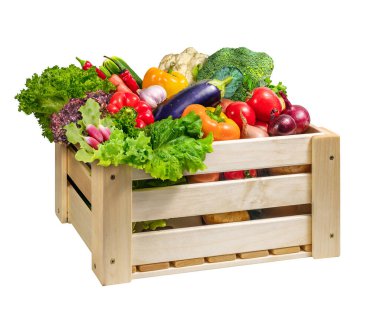 Ağaç sandık ağzına kadar beyaz üzerine izole edilmiş taze ve canlı sebzelerle dolu.