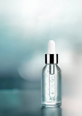 Soyut mavi arkaplan üzerine klasik damlalık tasarımlı kozmetik serum şişesi.