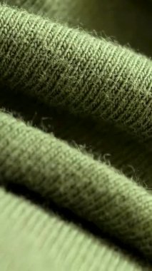 Soft green knit fabric that beautifully showcases its intricate textures and craftsmanship vertical background