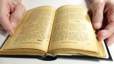 Old German Hymn Book and Hands on White Background