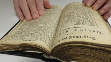 Old German Bible and Hands on White Background Alte Deutsche Bibel