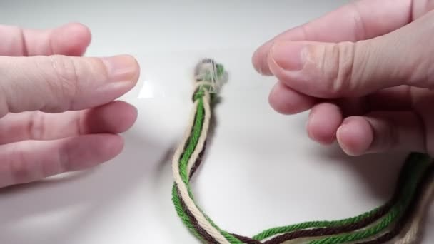 スティッキーテープで糸を結ぶ友情のブレスレットを作る — ストック動画