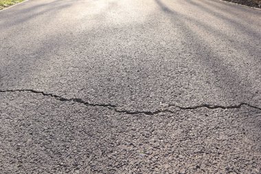 Çatlaklar ve çiziklerle asfalt yol