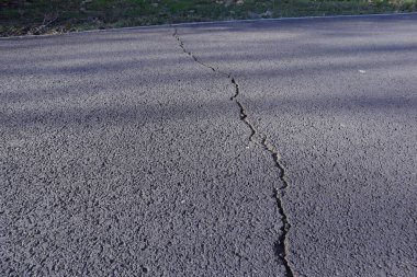 Çatlaklar ve çiziklerle asfalt yol