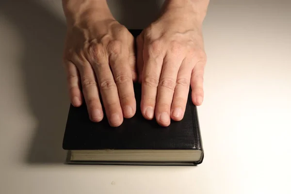 黑色圣经和白色背景的手 — 图库照片