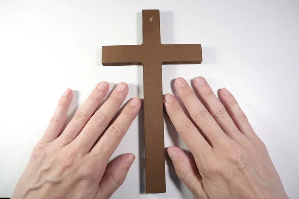 hands of a man with a cross on a white background