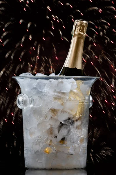 Bottle of Champagne in an ice bucket on a festive background and straw huts