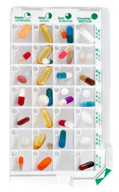 Daily pill box with medications and nutritional supplements. Closeup.white background.