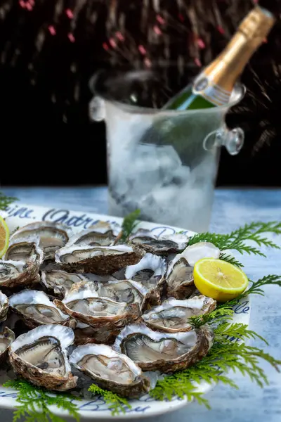 A dish with oysters on a table with festive decor. Christmas celebration. Close-up.