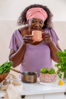 Kadın beyaz bardakta sebze çorbası içiyor otlar, baharatlar ve yeşilliklerle. Sebze. Paleo vegan diyeti