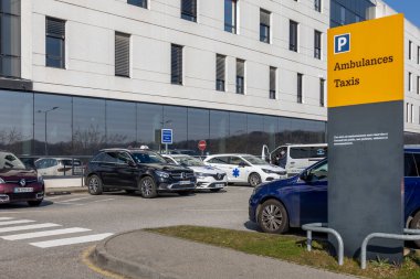 Araçlar modern bir hastanede ambulanslar ve taksiler için ayrılmış organize bir alana park edilmiştir. Gün boyunca uygun boşluklara giden işaretleri temizle.