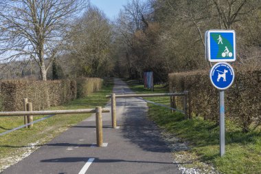 Çitlerle kaplı sakin bir patika aylakları ve bisikletçileri davet eder. Açık belirtiler yayalar ve köpekler için belirlenmiş alanları gösteriyor. Açık hava eğlencelerinin özünü yakalıyorlar..