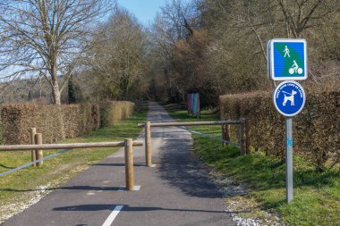 Çitlerle kaplı sakin bir patika aylakları ve bisikletçileri davet eder. Açık belirtiler yayalar ve köpekler için belirlenmiş alanları gösteriyor. Açık hava eğlencelerinin özünü yakalıyorlar..