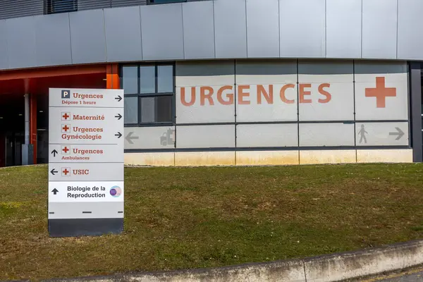 Açık yön işaretleri modern bir tıbbi tesiste çeşitli acil servislerin olduğunu gösteriyor. Binada önemli bir acil durum girişi ve hasta bakımı için birden fazla bölüm yer alıyor..