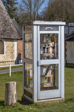 Dönüştürülmüş bir telefon kulübesi, kırsal bir Fransız köyünde küçük sevimli bir kütüphane olarak hizmet veriyor. Kitaplarla dolu raflar yerel sakinleri ve ziyaretçileri okumaya ve paylaşmaya davet ediyor.