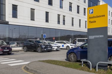 Araçlar modern bir hastanede ambulanslar ve taksiler için ayrılmış organize bir alana park edilmiştir. Gün boyunca uygun boşluklara giden işaretleri temizle.