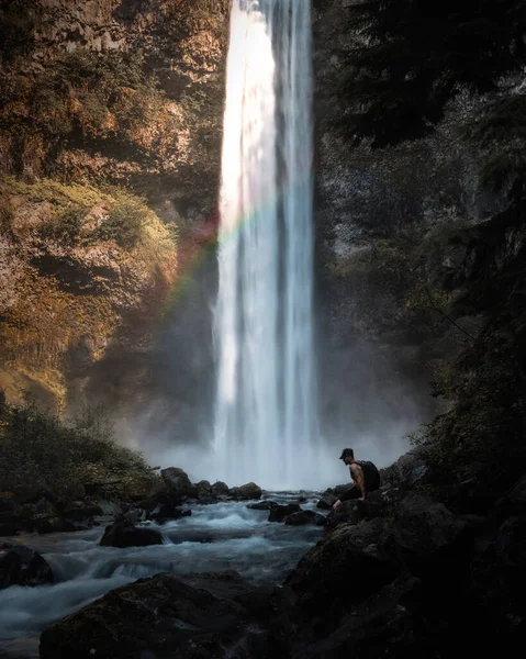 Stock image lonely man sitting by waterfall