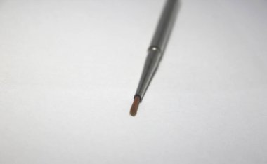 Küçük suluboya fırça, paslanmaz çelik saplı, modern tasarımlı. Sapı sökülebilir, fırça kahverengi renkli. Kenar ya da uç görünümü seçici odak.