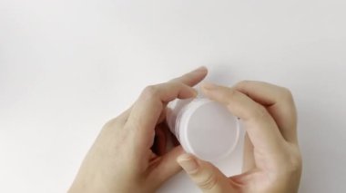 İnsan eli ilaç kutusunu açar, kırmızı ve beyaz ilaç haplarını alır ve hapları alır. Yatay beyaz arkaplanda izole edilmiş sağlık hizmeti temalı görüntüler.