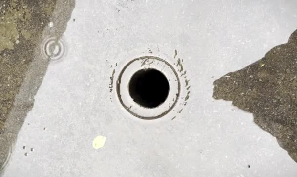 在水平面比背景下 雨水水坑涌进圆圆的室外小街金属排水沟的排水道隔离镜头 — 图库视频影像