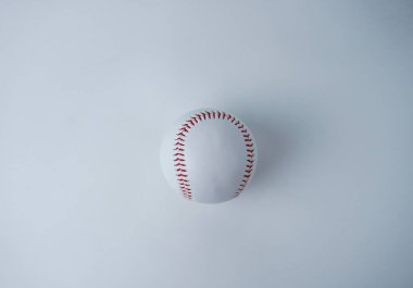 Beyaz ve kırmızı renkli beyzbol topu objesi fotoğrafçılığı yatay beyaz arka planda üst açıdan izole edilmiştir..