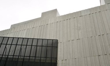 Modern basit ve minimalist dış görünüşlü yüksek gri renkli bina tasarımı yatay gökyüzü arka planında izole edildi.