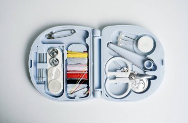 Küçük ölçekli kompakt seyahat terzilik ya da dikiş aletleri plastik mavi konteynır deposunda. Nesne fotoğrafçılığı beyaz arkaplanda izole edildi.