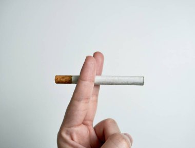 Human hand finger holding cigarette filter object pose isolated on horizontal ratio white background photography. clipart