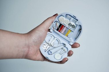 Kahverengi tırnak cilasıyla küçük, kompakt seyahat boyutunda dikiş seti fotoğrafçılığı yatay, düz beyaz ya da açık gri arkaplanda izole edilmiş..