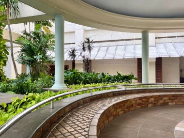 Park alanı banka oturma alanı yatay bina dış ve yeşil bitki yaprakları izole.