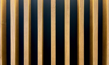 Modern stil duvar iç tasarımı. Siyah yatay duvar arka planında tahta panel çizgileri.