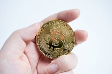 El ele tutuşan altın bitcoin kripto para birimi beyaz arka planda izole edildi.