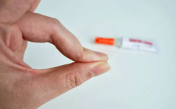 İnsan el parmakları yapıştırıcıyla yapıştırılmış güçlü bir yapıştırıcı. Yatay beyaz arkaplanda izole edilmiş cilt durumundan süper yapıştırıcı alınamıyor.