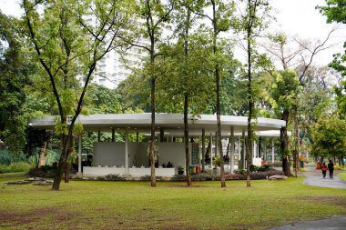 Jakarta, Endonezya - 15 Haziran 2024 - Tebet eko parkı topluluk binası beyaz yuvarlak bina yatay yeşil çimenler ve arka planda uzun ağaçlar.