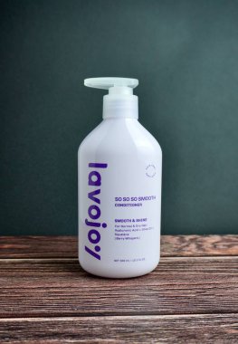 Jakarta, Endonezya - 20 Haziran 2024 - Lavojoy dutu mor saç bakım kremini fısıldıyor. Güzellik ve sağlık ürünleri ürünleri fotoğrafçılığı ahşap zemin üzerinde izole edilmiş..