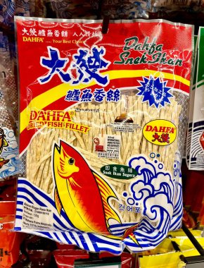 Jakarta, Indonesia - July 1st, 2024 - Dahfa dried fish fillet snack isolated on vertical ratio indoor supermarket shelf background. Snek makanan ringan rasa ikan. clipart