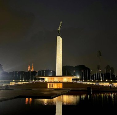 Jakarta, Endonezya - 11 Temmuz 2024 - Monumen patung pembebasan irian barat Lapangan banteng parkında gece ışıklar açıkken. Editör nesne fotoğrafçılığı koyu arkaplanda izole edildi.